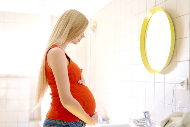 鏡を見つめる妊婦（妊娠中・授乳中にまつ毛美容液って使っていいの？）